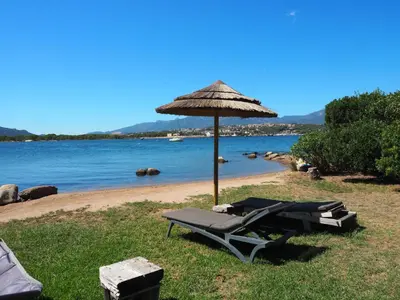 a living room with a leather couch and a table at Maranatha, front de mer avec plage in Porto-Vecchio