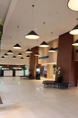 an empty lobby with pendant lights and tables at Radisson Blu Resort & Spa, Ajaccio Bay in Porticcio