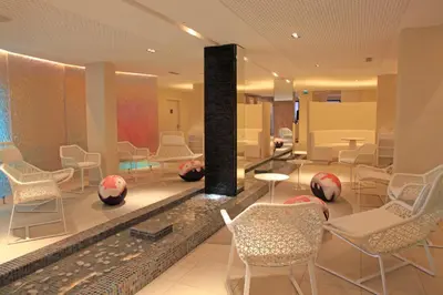 a lobby with chairs and tables and a fireplace at Radisson Blu Resort & Spa, Ajaccio Bay in Porticcio