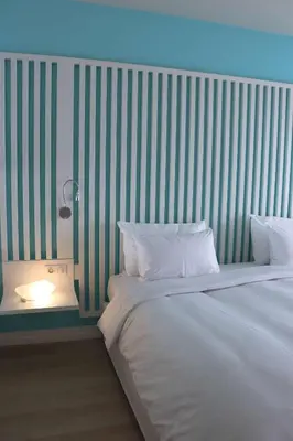 a bedroom with a white bed and a striped wall at Radisson Blu Resort & Spa, Ajaccio Bay in Porticcio