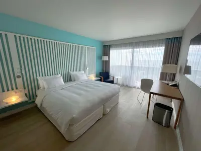 a bedroom with a large white bed and a desk at Radisson Blu Resort & Spa, Ajaccio Bay in Porticcio