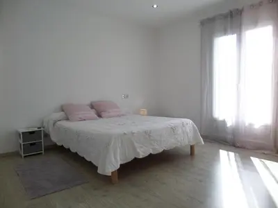 a white bedroom with a bed with pink pillows at Villa piscine vue mer in Pietrosella