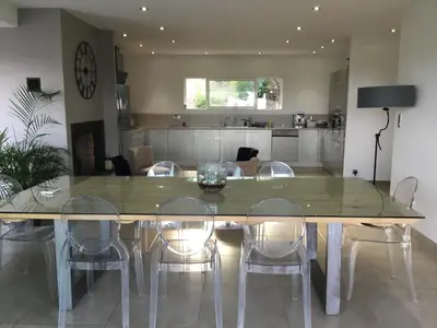 a large dining room table with chairs and a kitchen at Villa piscine vue mer in Pietrosella