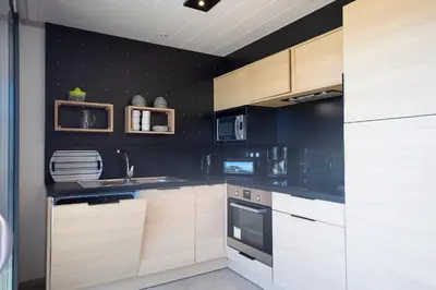 a kitchen with black walls and wooden cabinets at Casa e Natura in Moriani Plage
