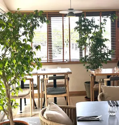 a dining room with tables and potted plants at Le Royal Hôtel Restaurant in Bonifacio