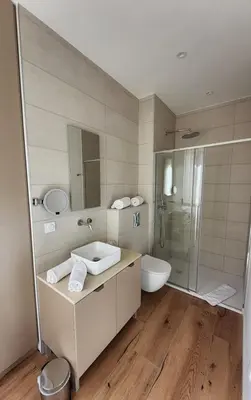 a bathroom with a sink and a toilet and a shower at Le Royal Hôtel Restaurant in Bonifacio