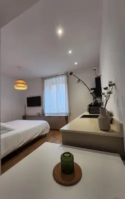 a bedroom with a bed and a table with a green object on it at Le Royal Hôtel Restaurant in Bonifacio