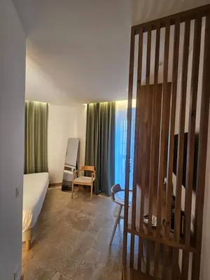 a hotel room with a bed and a table and chairs at Le Royal Hôtel Restaurant in Bonifacio