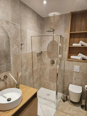 a bathroom with a shower and a sink and a toilet at Le Royal Hôtel Restaurant in Bonifacio