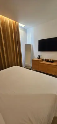 a hotel room with a bed and a flat screen tv at Le Royal Hôtel Restaurant in Bonifacio