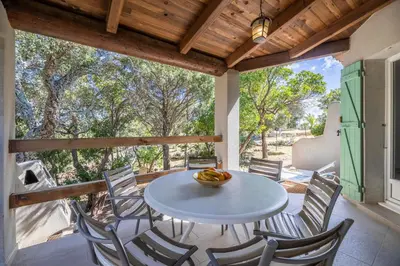 a patio with a table and chairs on a porch at Résidence Santa Monica in Bonifacio