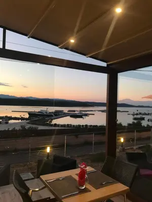 a dining room with a view of the water at Hôtel du Golfe in Bonifacio