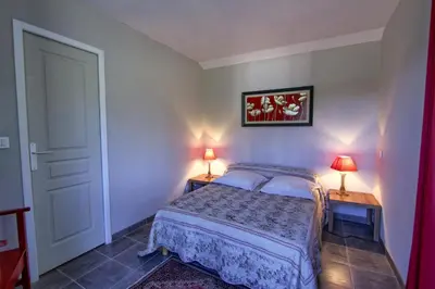 a bedroom with a bed and two lamps on two tables at A Ghjuvellina in Piedigriggio