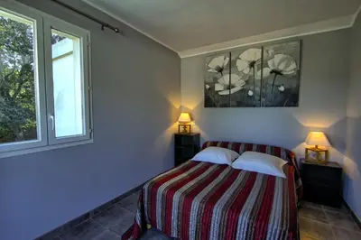 a bedroom with a bed with two lamps and a window at A Ghjuvellina in Piedigriggio