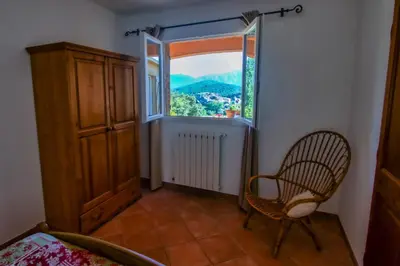 a room with a chair and a window at A Ghjuvellina in Piedigriggio