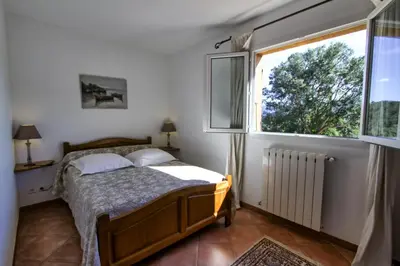 a bedroom with a bed and a large window at A Ghjuvellina in Piedigriggio