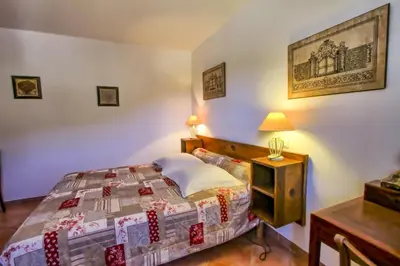 a bedroom with a bed and a table with a lamp at A Ghjuvellina in Piedigriggio