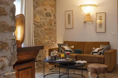 a living room with a couch and a table at Hôtel La Dimora & Spa in Saint-Florent