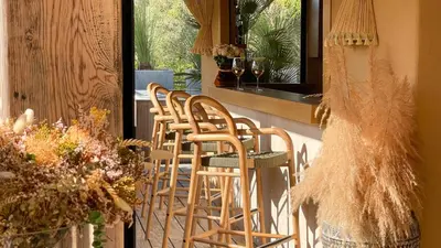 a row of chairs on a porch with wine glasses at Hôtel La Dimora & Spa in Saint-Florent