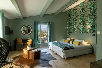 a bedroom with a bed and a large window at Hôtel La Dimora & Spa in Saint-Florent