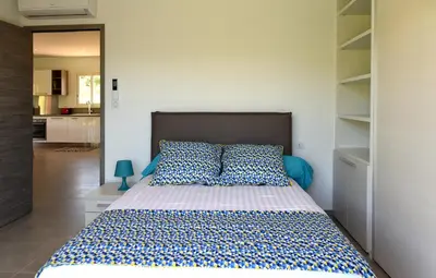 a bedroom with a large bed with blue and white sheets at Sarl Valinco Locations in Olmeto