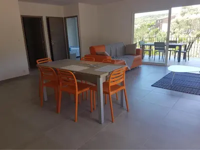 a table and chairs in a living room with a couch at Sarl Valinco Locations in Olmeto