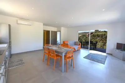 a living room with a table and chairs and a couch at Sarl Valinco Locations in Olmeto
