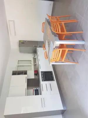 an empty white room with orange chairs on shelves at Sarl Valinco Locations in Olmeto
