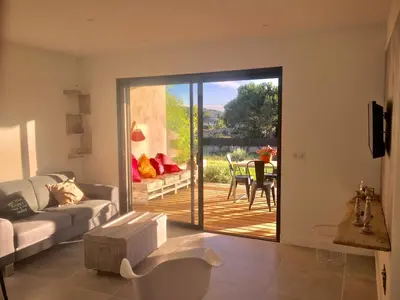 a living room with a sliding door to a patio at Résidence U Rapalinu in Molini