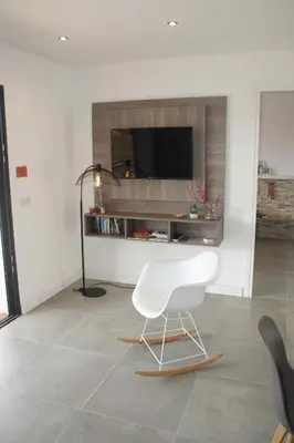 a living room with a white chair and a television at Résidence U Rapalinu in Molini