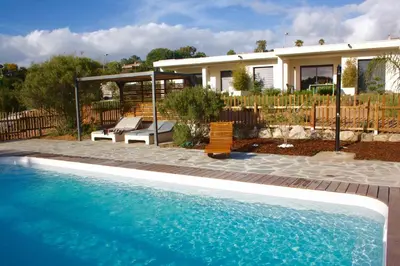a house with a swimming pool in front of a house at Résidence U Rapalinu in Molini