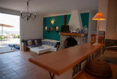 a living room with a table and a fireplace at Casa Vadde Lungha superbe vue mer 8 personnes in Coti-Chiavari