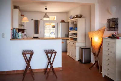 a kitchen with a counter and two stools at Casa Vadde Lungha superbe vue mer 8 personnes in Coti-Chiavari