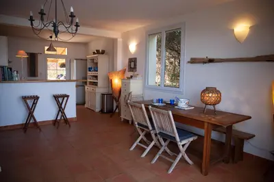 a kitchen and dining room with a wooden table and chairs at Casa Vadde Lungha superbe vue mer 8 personnes in Coti-Chiavari