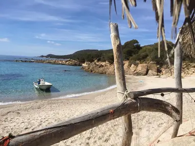 a boat in the water on a beach at Casa Vadde Lungha superbe vue mer 8 personnes in Coti-Chiavari