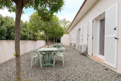 a group of tables and chairs in a courtyard at Hôtel Des Nacres in Ventiseri