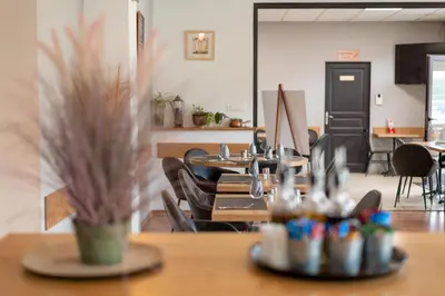 a restaurant with tables and chairs in a room at Hôtel Des Nacres in Ventiseri