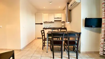 a kitchen and dining room with a table and chairs at Vacancéole - Résidence Lisa Maria in Favone
