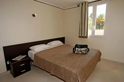 a bedroom with a bed with a bag on it at Vacancéole - Résidence Lisa Maria in Favone