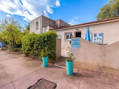 a building with two potted plants in front of it at Vacancéole - Résidence Lisa Maria in Favone