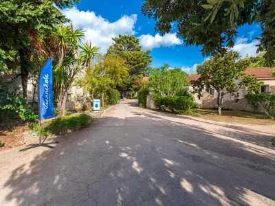 an empty street with a blue sign in the middle at Vacancéole - Résidence Lisa Maria in Favone
