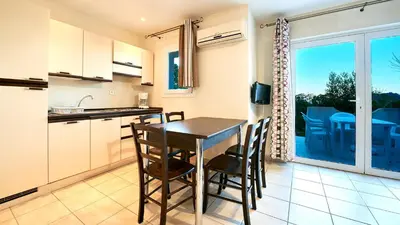 a kitchen and dining room with a table and chairs at Vacancéole - Résidence Lisa Maria in Favone