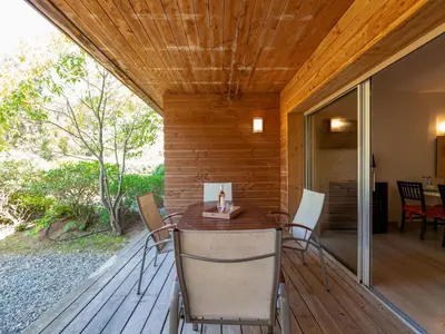 a wooden deck with a table and chairs on it at Apartment Cala Sultana-3 by Interhome in Usciolo