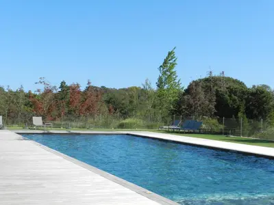 a swimming pool with a deck and a bench at Apartment Cala Sultana-3 by Interhome in Usciolo