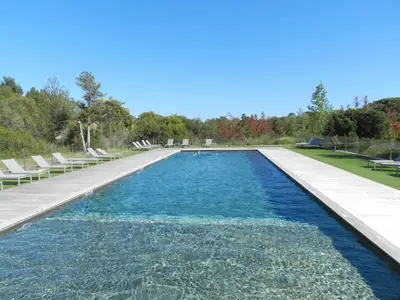 a swimming pool with chairs and blue water at Apartment Cala Sultana-7 by Interhome in Usciolo