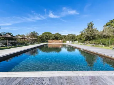 a swimming pool in a park with blue water at Apartment Cala Sultana-7 by Interhome in Usciolo