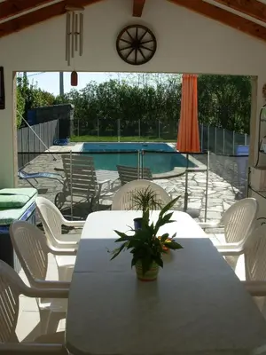 a patio with a table and chairs and a pool at Villa mit grosser Sommerküche und Pool, 8 Minuten zum Sandstrand Cap Sud in LʼArena