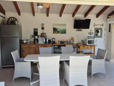 a dining room with a table and chairs at Villa mit grosser Sommerküche und Pool, 8 Minuten zum Sandstrand Cap Sud in LʼArena