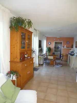 a living room with a kitchen and a dining room at Villa mit grosser Sommerküche und Pool, 8 Minuten zum Sandstrand Cap Sud in LʼArena
