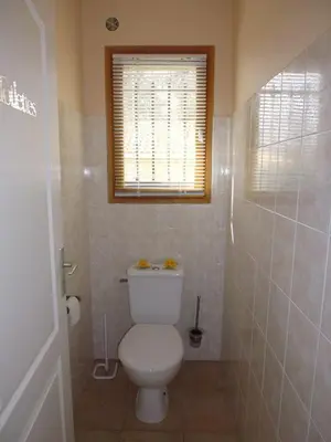 a bathroom with a white toilet and a window at Villa mit grosser Sommerküche und Pool, 8 Minuten zum Sandstrand Cap Sud in LʼArena